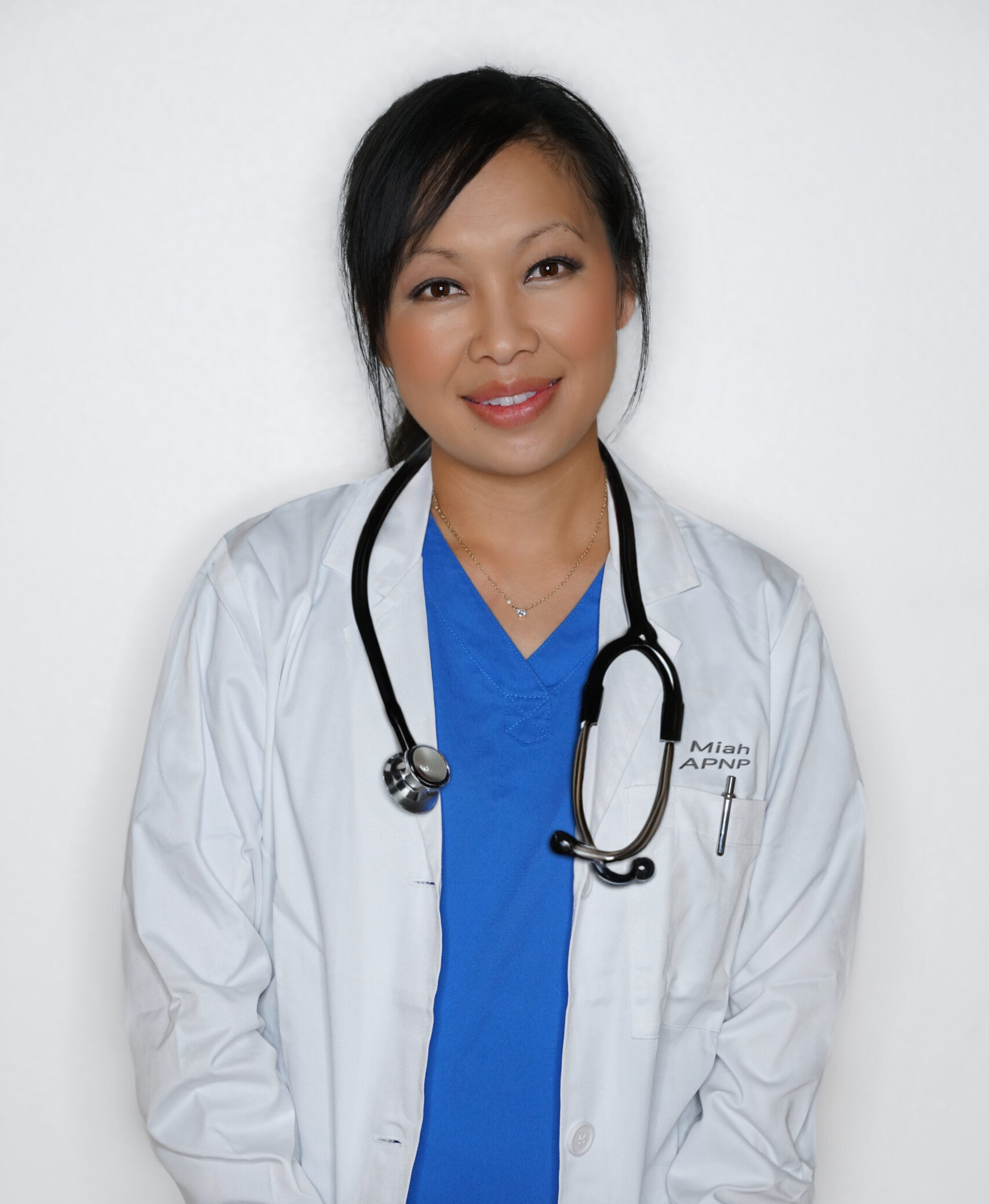 A woman in a white lab coat and blue shirt