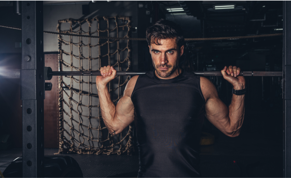 A man holding onto a bar in the gym